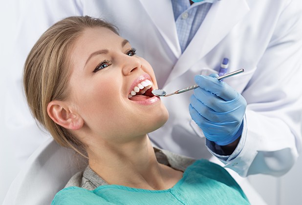 Patient receiving dental checkup to prevent dental emergencies