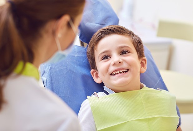 Young boy smiling at dentist during children's dentistry checkup