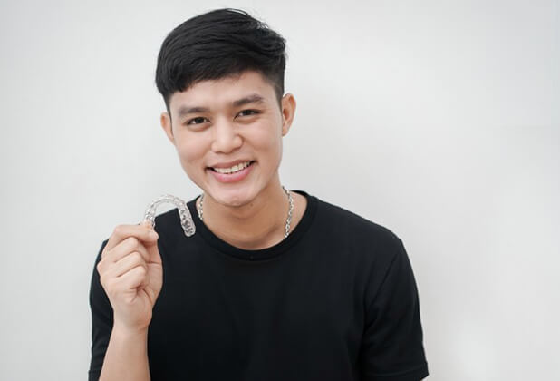 young man holding a tray for Invisalign in Beverly Hills 