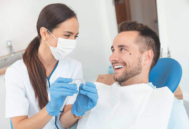 dentist in Beverly Hills showing a patient how Invisalign works 