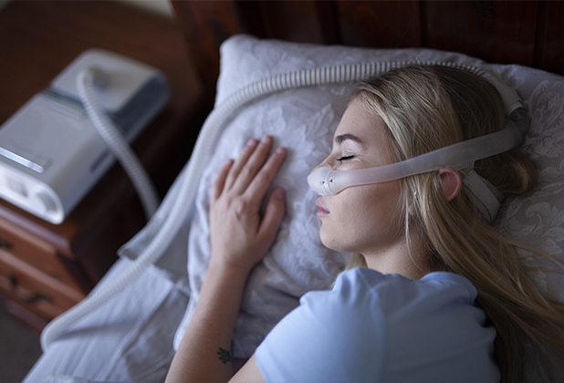 Woman with CPAP nose mask and oral appliance for sleep apnea